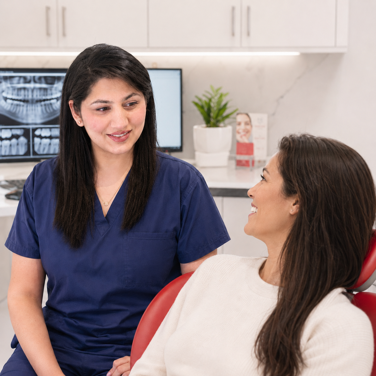 Friendly general dentist speaking with a smiling patient at Lara Dental Prime